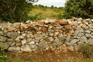 Entretien du mur sur le GR4 à la sortie de Saint-Remèze sur le Dévès. 